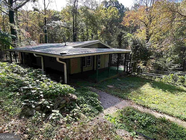 exterior space featuring a sunroom and a lawn