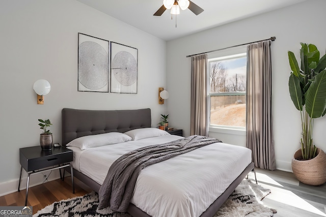 bedroom featuring multiple windows, baseboards, and wood finished floors