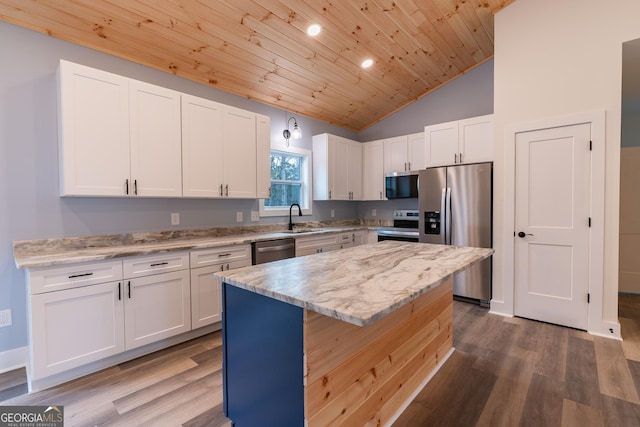 kitchen featuring a kitchen island, appliances with stainless steel finishes, wood finished floors, white cabinetry, and a sink