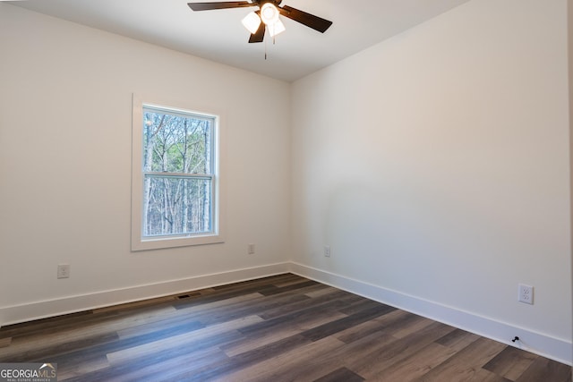 empty room with visible vents, dark wood-style floors, baseboards, and ceiling fan