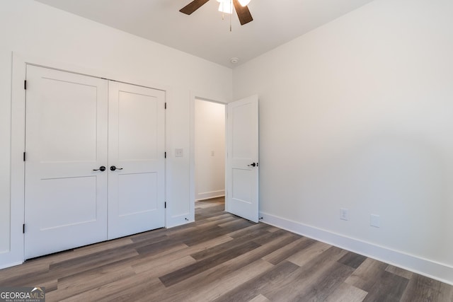 unfurnished bedroom with ceiling fan, a closet, baseboards, and wood finished floors