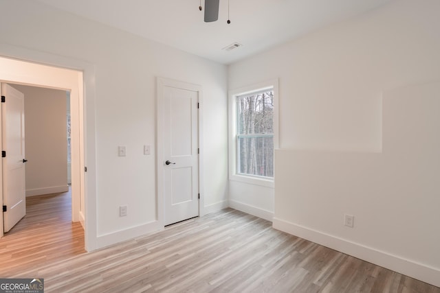 unfurnished bedroom featuring visible vents, baseboards, ceiling fan, and light wood finished floors