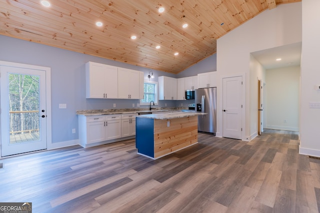 kitchen featuring wood ceiling, white cabinetry, appliances with stainless steel finishes, and a kitchen island