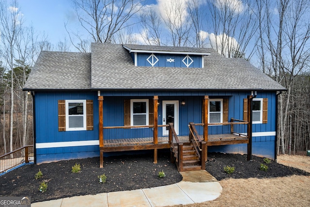 view of front facade with a porch, a shingled roof, and board and batten siding