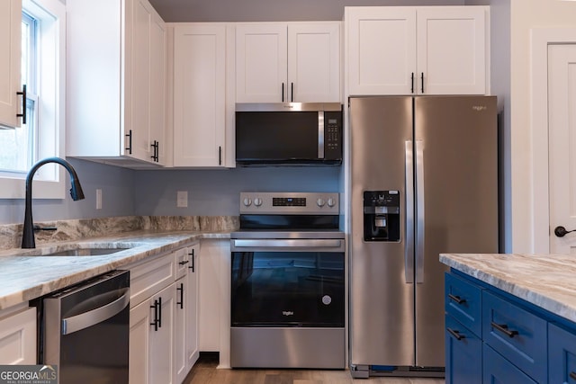 kitchen with white cabinetry, appliances with stainless steel finishes, and a sink