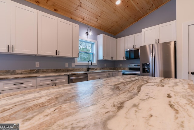 kitchen featuring light stone counters, white cabinetry, stainless steel appliances, and wood ceiling