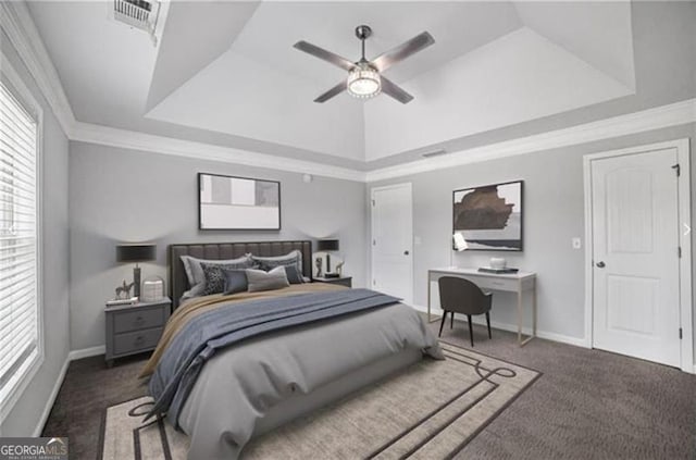 carpeted bedroom with a tray ceiling, ceiling fan, and ornamental molding