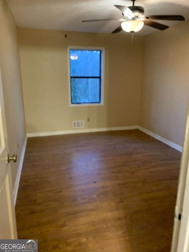 unfurnished room featuring ceiling fan and dark hardwood / wood-style flooring