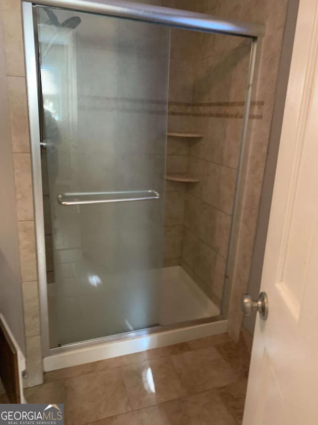 bathroom featuring an enclosed shower and tile patterned flooring