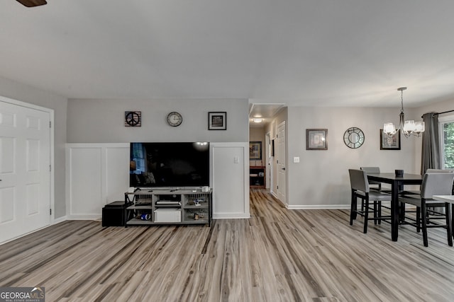 living room featuring light hardwood / wood-style flooring and an inviting chandelier