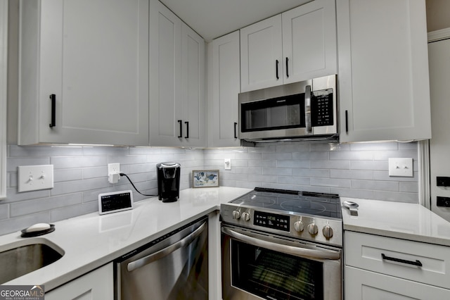 kitchen featuring white cabinets, decorative backsplash, and stainless steel appliances