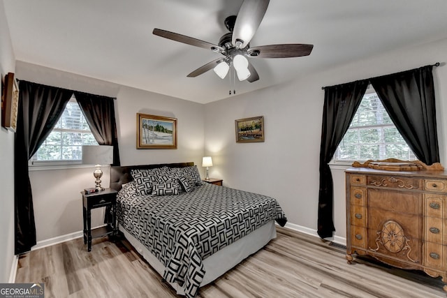 bedroom with multiple windows, ceiling fan, and light wood-type flooring