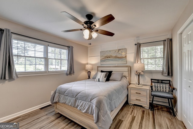 bedroom with ceiling fan, light wood-type flooring, and a closet