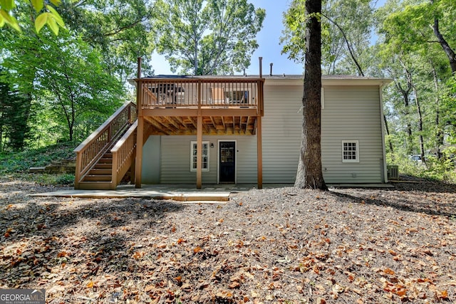 rear view of house featuring central AC unit and a deck