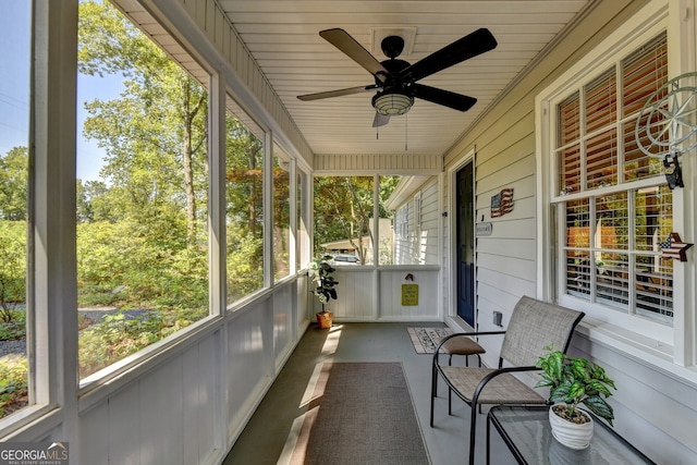 unfurnished sunroom with ceiling fan