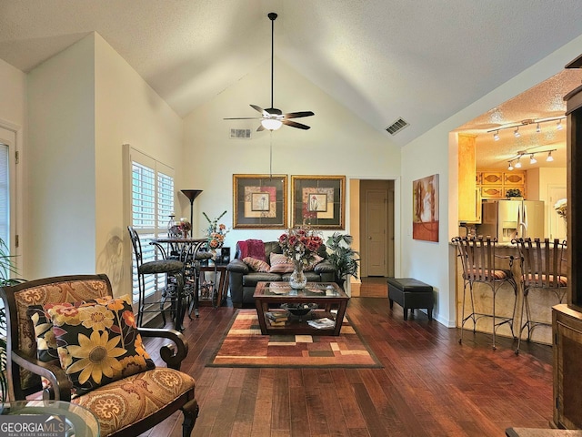 living area with ceiling fan, dark hardwood / wood-style floors, vaulted ceiling, and a brick fireplace