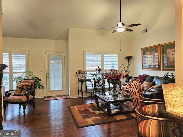 living room featuring dark wood-type flooring, ceiling fan, lofted ceiling, and a brick fireplace