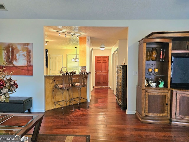 kitchen featuring light stone countertops, appliances with stainless steel finishes, kitchen peninsula, and a textured ceiling