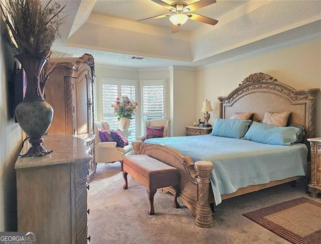 carpeted bedroom featuring crown molding, ceiling fan, and a tray ceiling