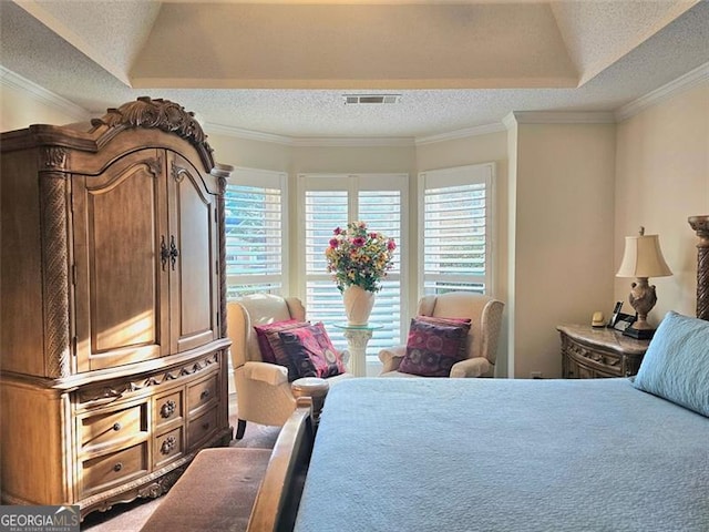 bedroom with crown molding, a raised ceiling, and a textured ceiling