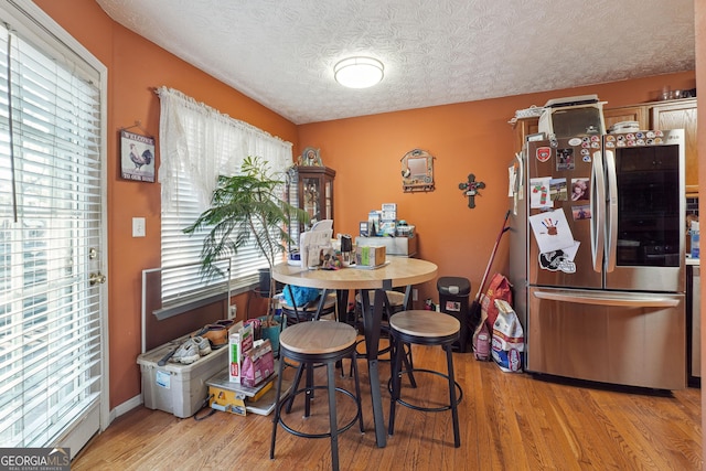 dining room featuring a textured ceiling and light wood-type flooring