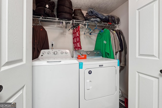 laundry room featuring washer and clothes dryer and a textured ceiling