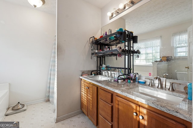 bathroom with vanity and a textured ceiling