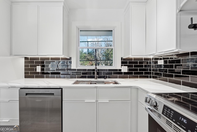 kitchen with white cabinets, appliances with stainless steel finishes, light stone countertops, and sink