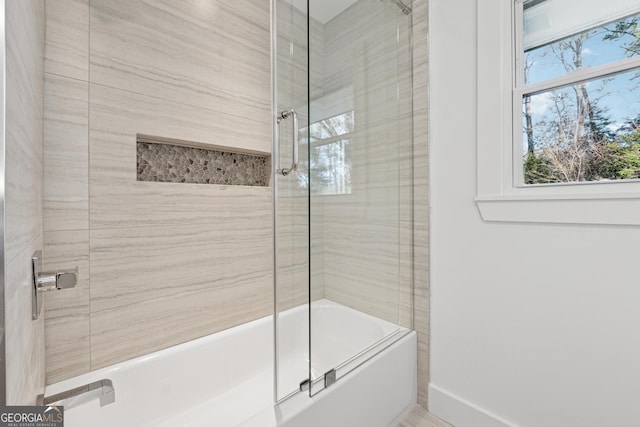 bathroom with combined bath / shower with glass door