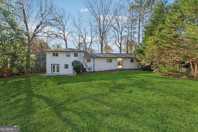 rear view of property with a lawn and a patio