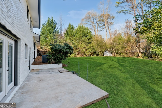 view of yard featuring central air condition unit and a patio