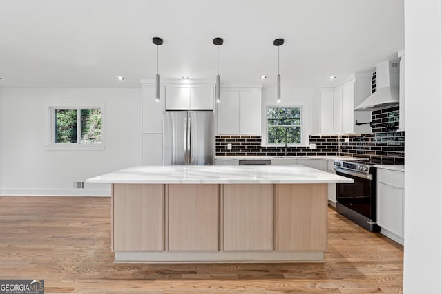 kitchen featuring stainless steel fridge, electric range oven, white cabinetry, and premium range hood