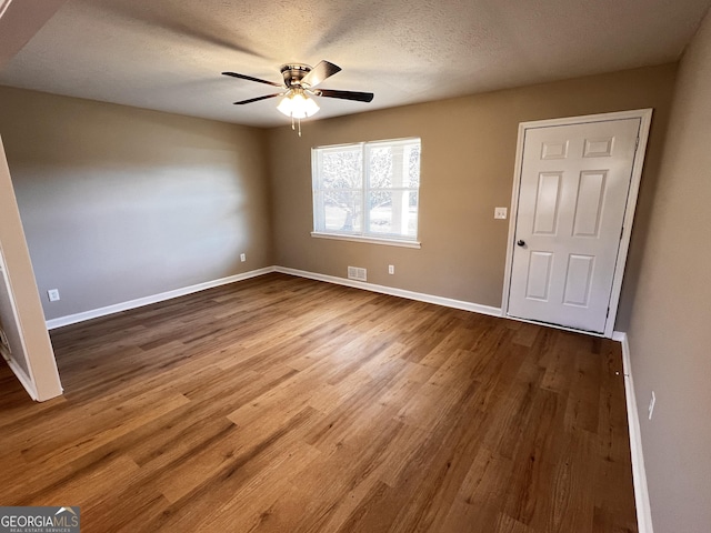 foyer with wood-type flooring, a textured ceiling, and ceiling fan