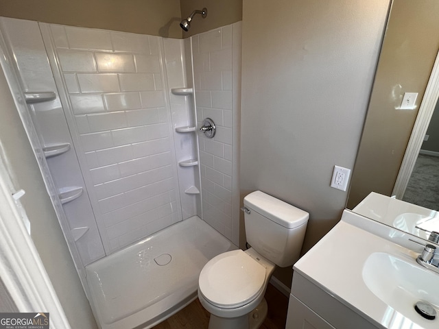 bathroom featuring vanity, toilet, and walk in shower