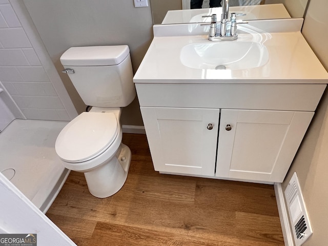 bathroom with vanity, toilet, wood-type flooring, and a shower