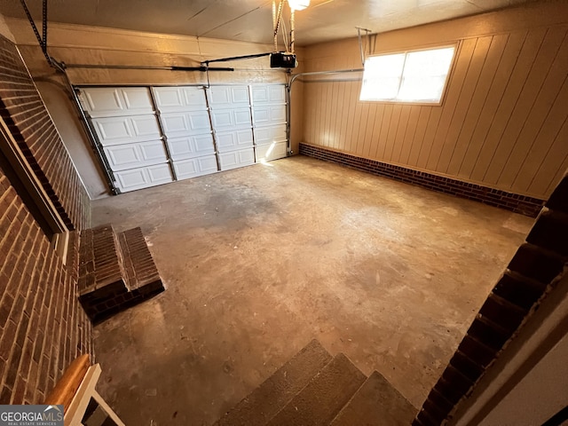 garage featuring wood walls and a garage door opener