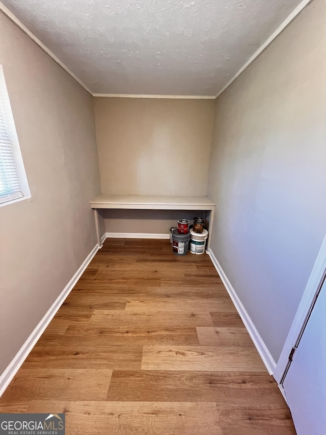 clothes washing area featuring a textured ceiling and light wood-type flooring