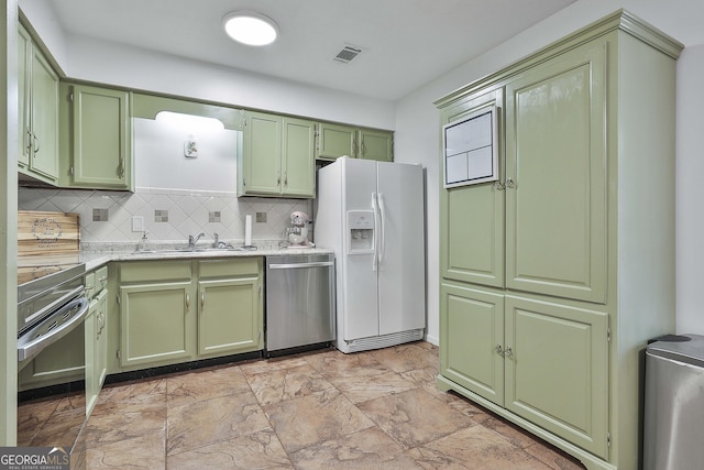 kitchen featuring dishwasher, green cabinets, sink, white fridge with ice dispenser, and tasteful backsplash