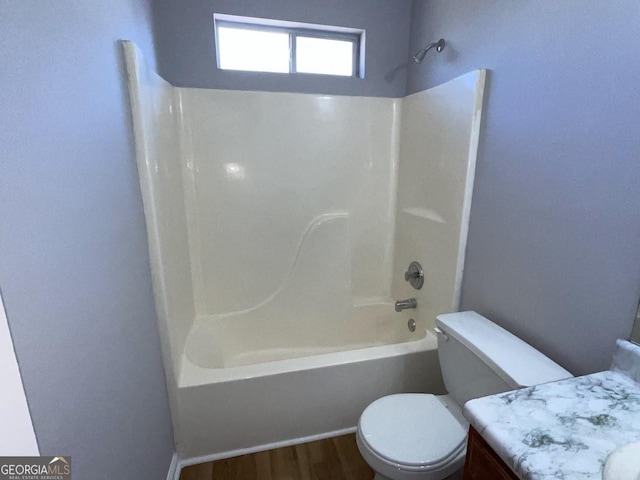 full bathroom with shower / bathing tub combination, vanity, wood-type flooring, and toilet