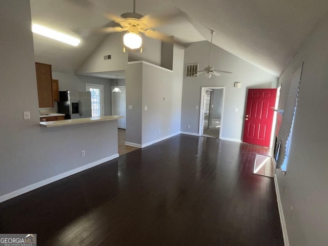 unfurnished living room with ceiling fan, dark hardwood / wood-style floors, and high vaulted ceiling