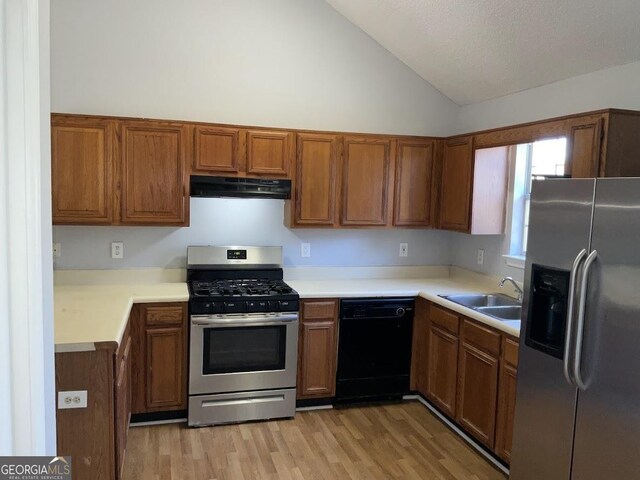 kitchen with light hardwood / wood-style flooring, sink, stainless steel appliances, and vaulted ceiling