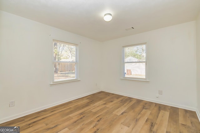 spare room with a healthy amount of sunlight and wood-type flooring