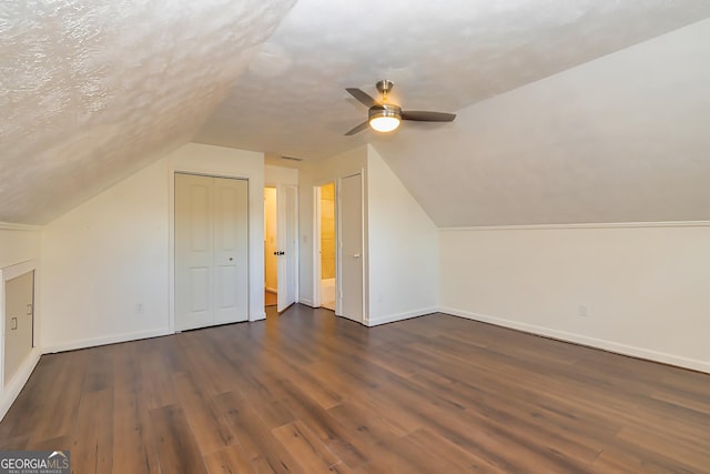 bonus room featuring a textured ceiling, dark wood-type flooring, ceiling fan, and lofted ceiling