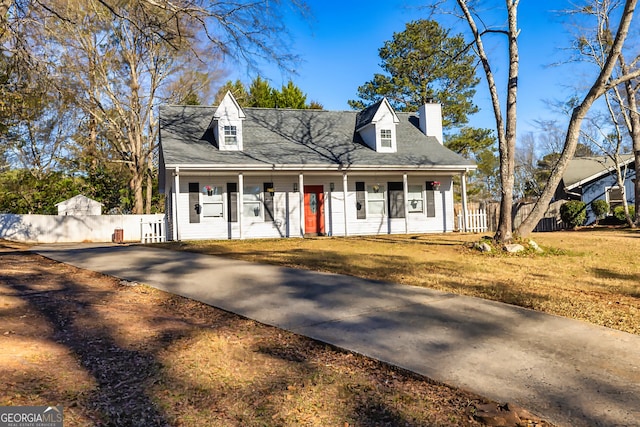 new england style home featuring covered porch and a front yard