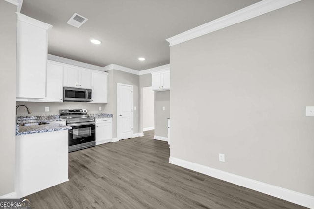 kitchen featuring white cabinets, sink, ornamental molding, light stone counters, and stainless steel appliances