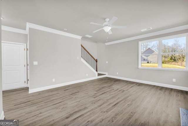 unfurnished living room featuring ceiling fan, ornamental molding, and hardwood / wood-style flooring