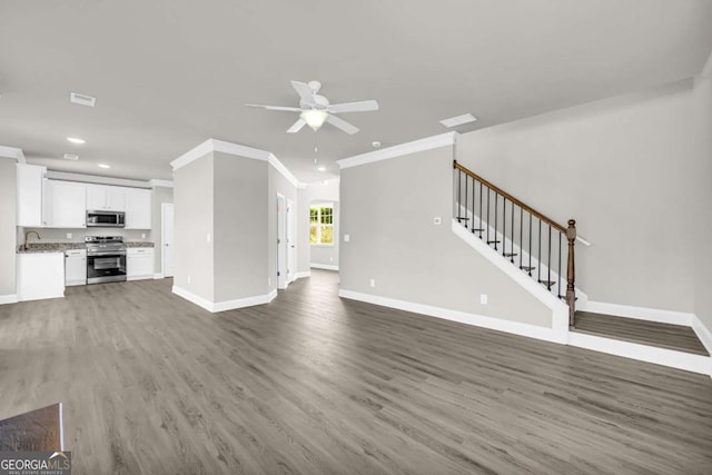 unfurnished living room with dark hardwood / wood-style floors, ceiling fan, ornamental molding, and sink