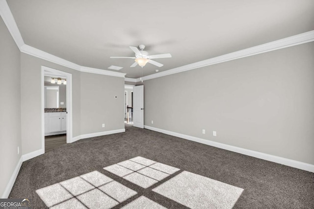 unfurnished bedroom with ceiling fan, dark carpet, ornamental molding, and ensuite bathroom