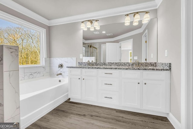 bathroom featuring a bath, crown molding, vanity, and wood-type flooring