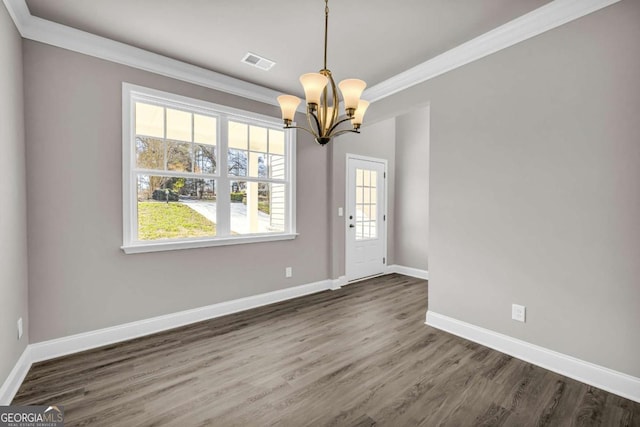 unfurnished dining area with crown molding, dark hardwood / wood-style floors, and an inviting chandelier